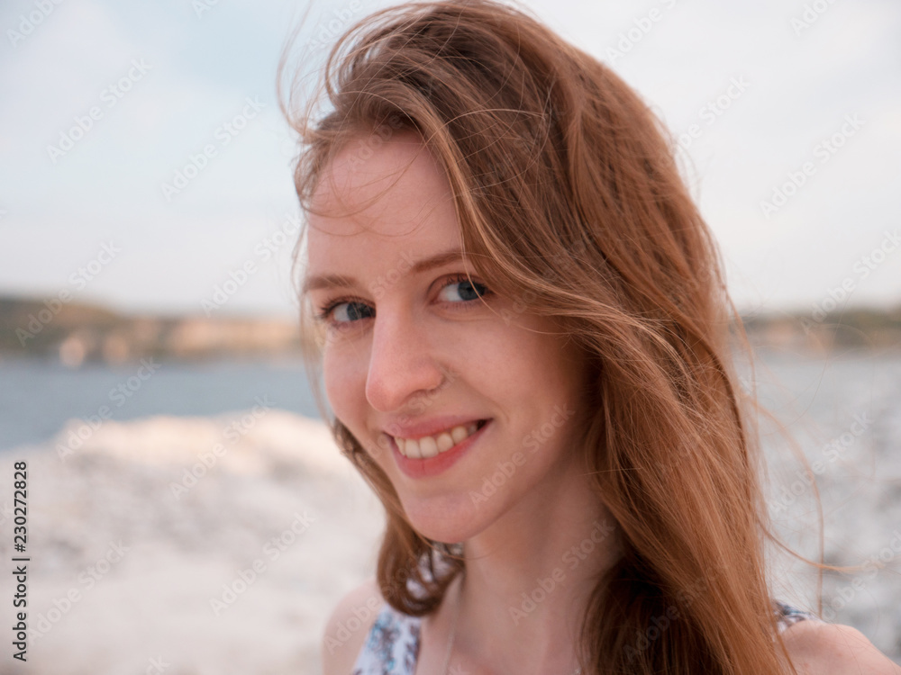 Close-up portrait of a young beautiful woman with against the backdrop of he bay, the hills in the sky Close-up portrait of a young beautiful woman with against the backdrop of he bay, the hills in the sky