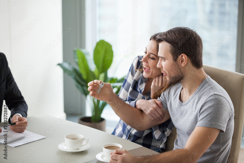 Young couple happy about buying, renting new apartment, home. Husband with keys in hands. Satisfied customers, clients. Closing deal, making agreement. Young couple happy about buying, renting new apartment, home. Husband with keys in hands. Satisfied customers, clients. Closing deal, making agreement.
