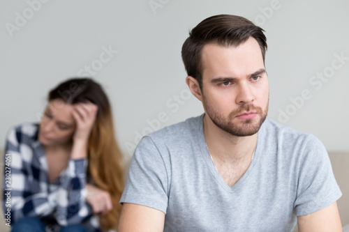 Head shot portrait sad, frustrated, desperate young man thinking of relationship problems. Troubles in family, misunderstanding, distrust. Young couple after quarrel photo