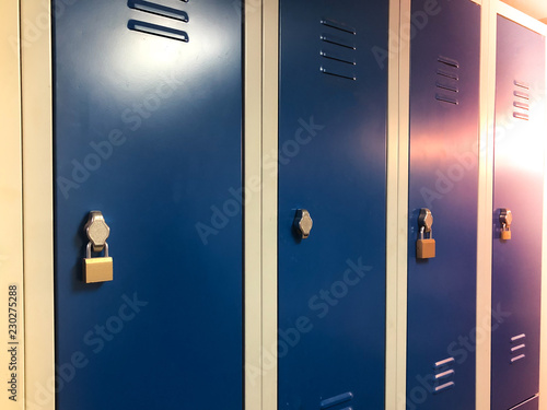 Industrial changing drawers, lockers with a blue doors. Some are locked with padlocks