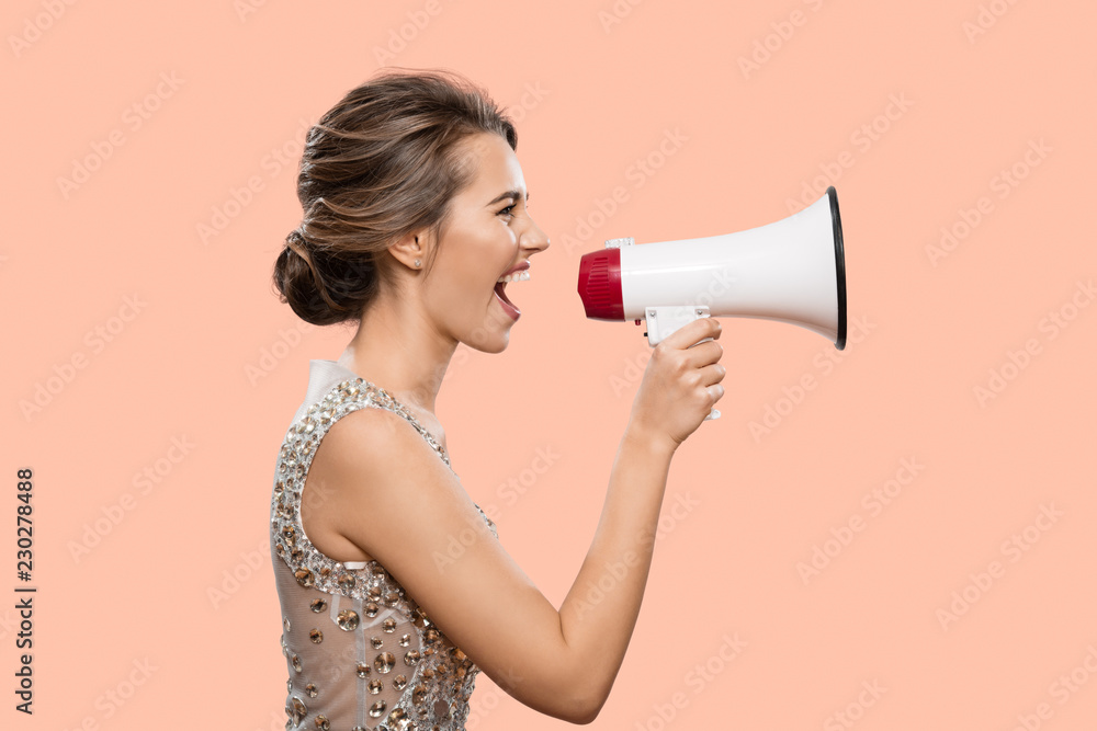 Woman shouting into a megaphone. Pink background. Woman shouting into a megaphone. Pink background.