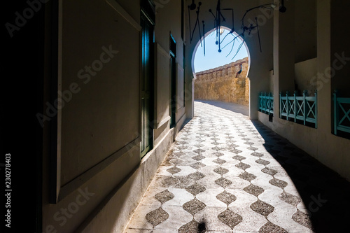 Contrastic view of the gate leading to old medina of the ancient city Asilah, Morocco photo