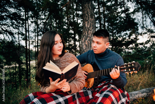 Summer Camp Fire. Tourism sexy photo. Cute couple kissing in the park on a sunny day. Adventure concept. Man and woman kissing. Couple in love. Camping fire. Love story. Romance lovers. Fashion photo.