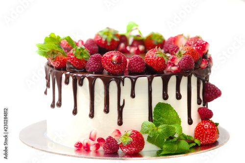 Foto cake covered with berries of raspberry strawberry pomegranate mint leaves doused