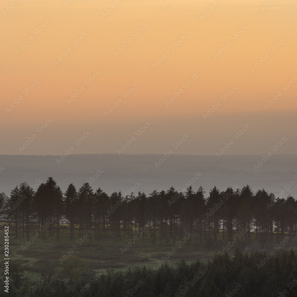 Stunning Autumn sunset landscape image of view from Leather Tor towards Burrator Reservoir in Dartmoor National Park Stunning Autumn sunset landscape image of view from Leather Tor towards Burrator Reservoir in Dartmoor National Park