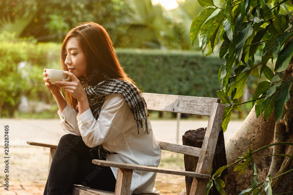 Naklejka premium Beautiful young teenage woman freelance have a cup of latte on sun light, freelance lifestyle conceptual