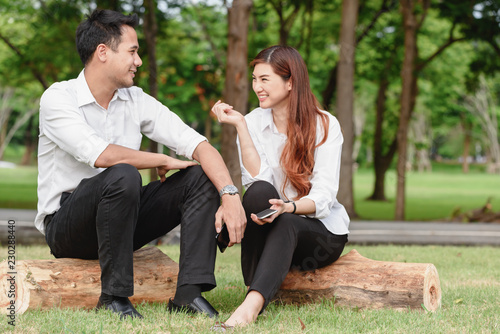 Man and woman in white shirt talk to each other in outdoors park photo