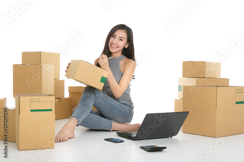 Young woman freelancer working and checklist and writing order with cardboard box on white background - SME business online and delivery concept © uinmine