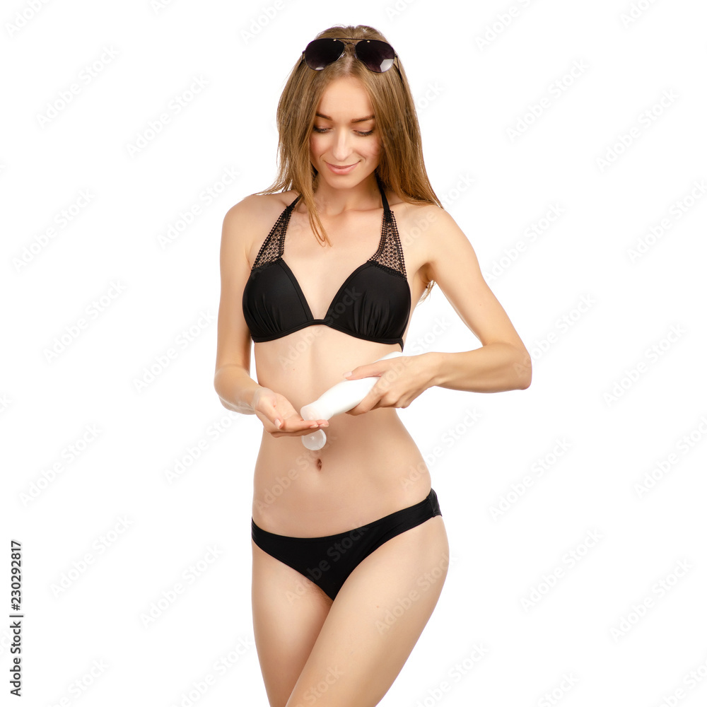 Fototapeta premium Beautiful woman in swimsuit sunglasses sunscreen cream on a white background. Isolation