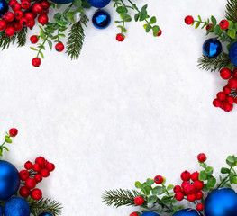 Christmas decoration. Frame of twigs christmas tree, christmas blue balls and red berries on snow with space for text. Top view, flat lay