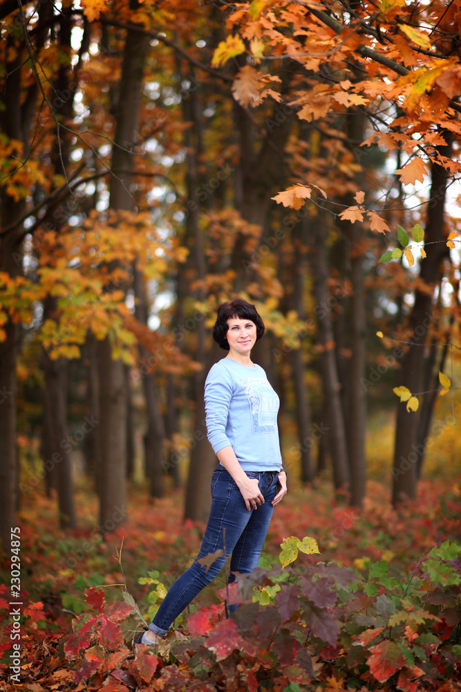 Girl in a yellow autumn forest. Beautiful young woman walks along the path of the autumn forest. Girl in a yellow autumn forest. Beautiful young woman walks along the path of the autumn forest.