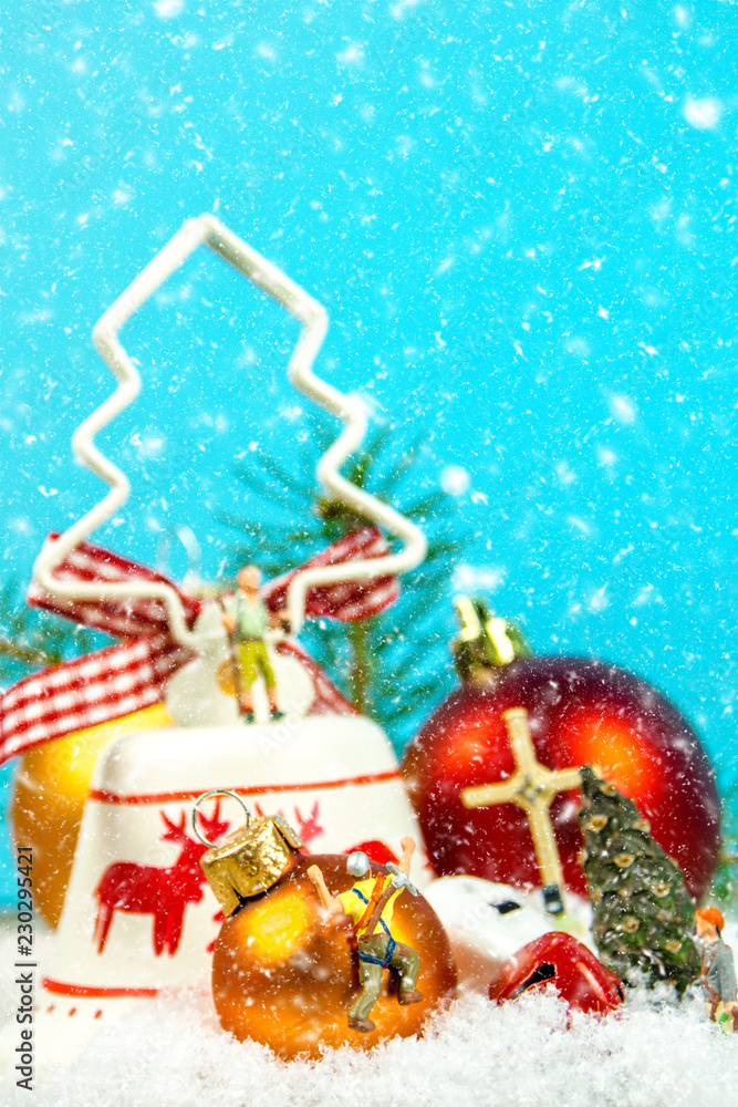 Christmas decoration with snow falling and miniature figurines on blue background
