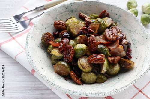 Traditional warm salad at Thanksgiving. Brussels sprouts, onions, bacon, cranberries and pecans. photo