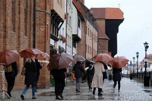 Polska, Gdańsk - turyści z brązowym parasolami zwiedzający miasto w deszczową pogodę © Iwona