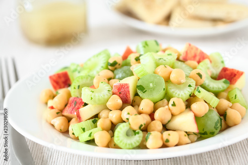 Fresh vegan chickpea, celery, grape and apple salad with parsley, photographed with natural light (Selective Focus, Focus in the middle of the image)