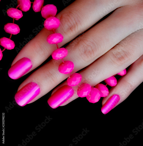 Women's fingers with pink beads and beautiful manicure. Copy space