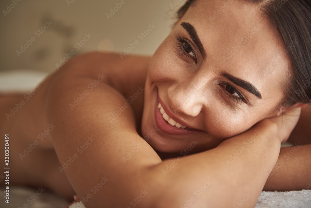 Smiling portrait. Positive relaxed young lady wearing no clothes while being in the hammam and smiling happily Smiling portrait. Positive relaxed young lady wearing no clothes while being in the hammam and smiling happily