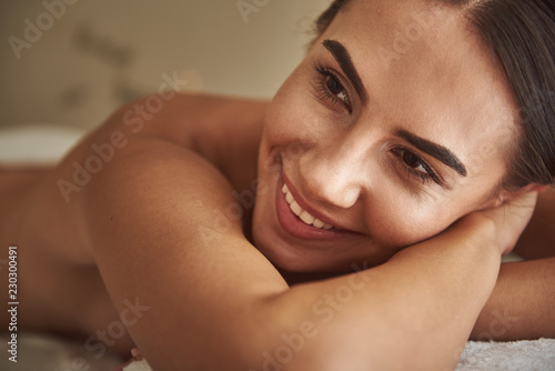 Smiling portrait. Positive relaxed young lady wearing no clothes while being in the hammam and smiling happily