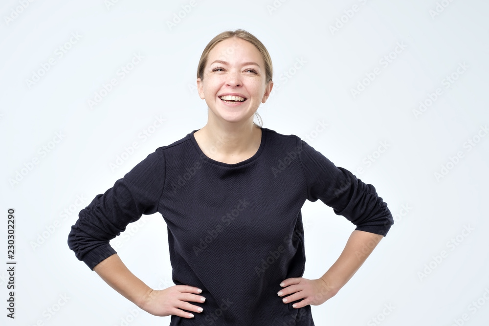Φωτογραφία Happy cheerful young woman wearing black clothes rejoicing at positive news or birthday gift, looking at camera laughing