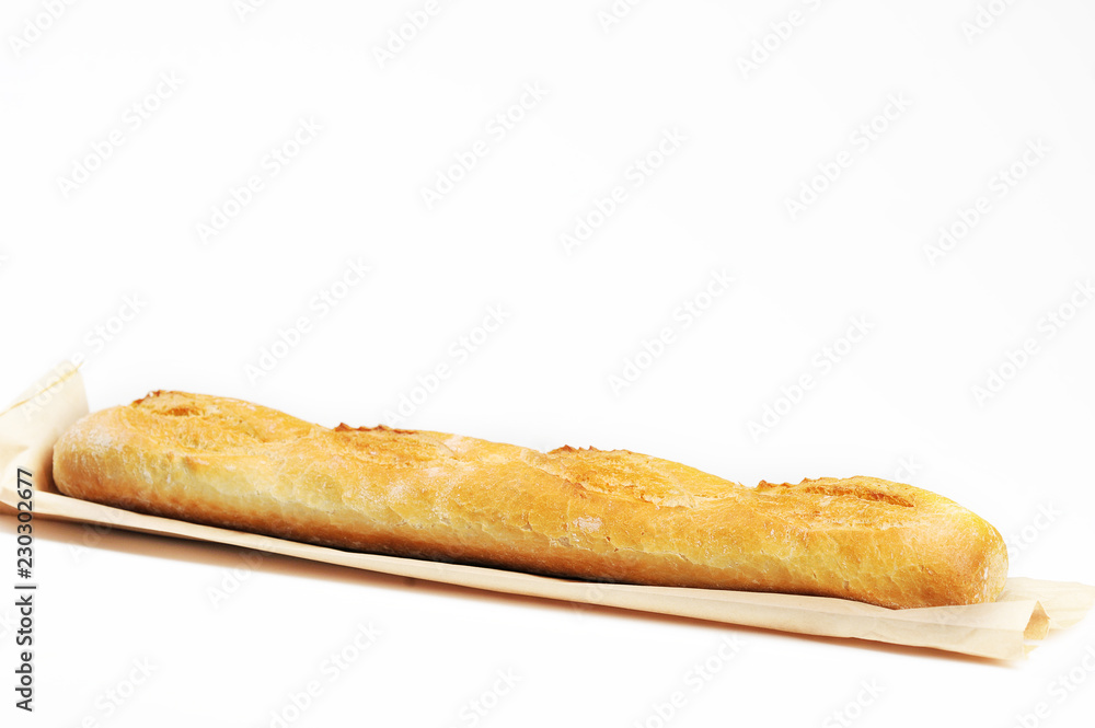 Baguette with a crisp on a sheet of paper. Close-up. White background.