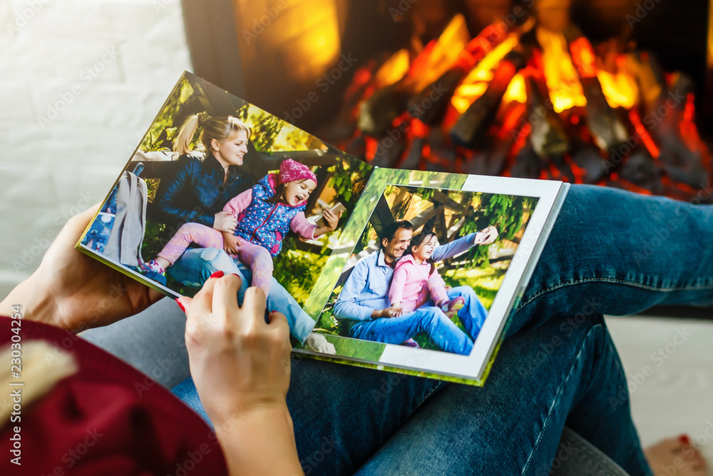 Φωτογραφία High angle view of young girl looking through photo album at home