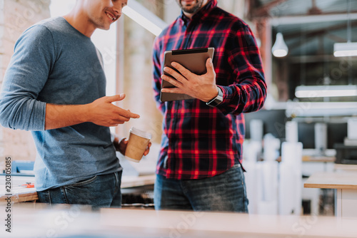Experts in field of graphic design are looking through necessary material for work while using laptop