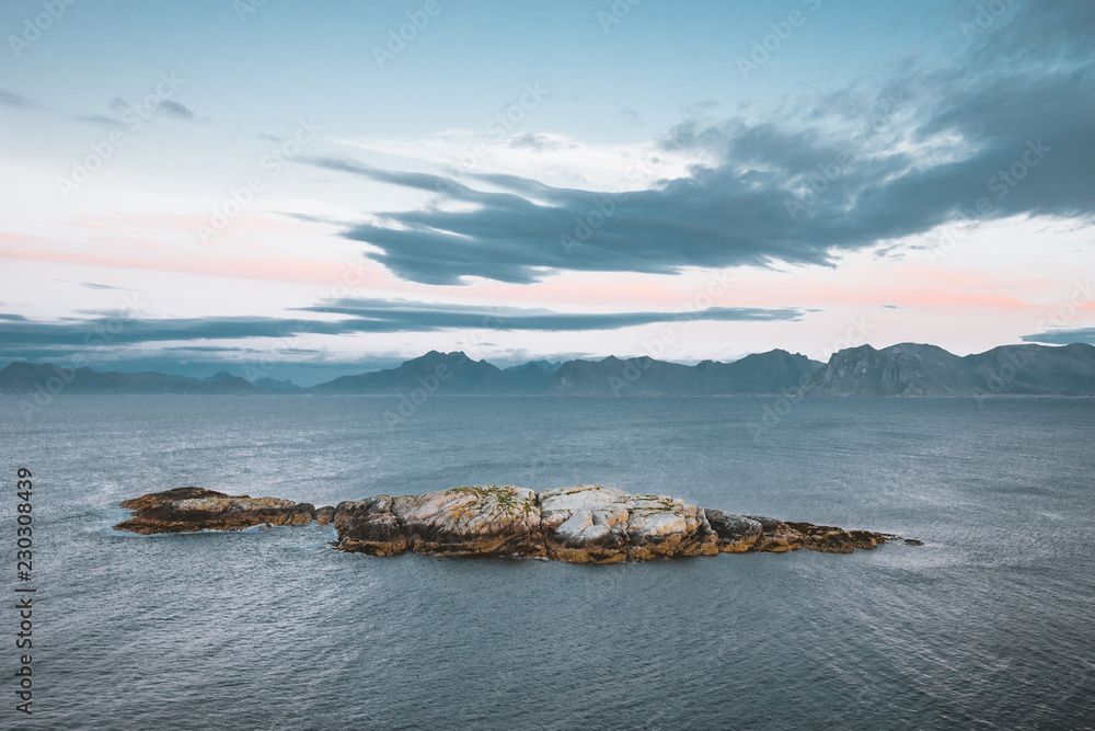 Sunrise and Sunset at Henningsvaer, fishing village located on several small islands in the Lofoten archipelago, Norway over a blue sky with clouds.