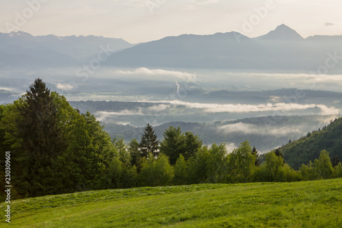 Fototapeta Naklejka Na Ścianę i Meble -  Spring mountain landscape in Slovenia, morning mist over the valley
