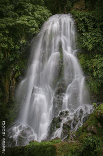 Majestic waterfall in forest, Portugal. Ribeira dos Caldeiroes Nature Reserve at Achada, Nordeste, Azores