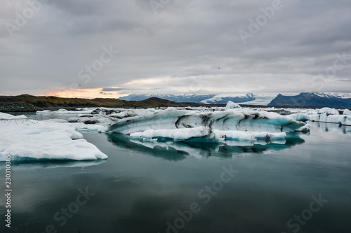 Blue icebergs floating in Jokulsarlon glacial  Iceland in summer at dusk  reflections in the water.