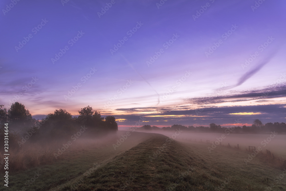A new day awakens with a lot of color in the sky and fog on the ground. Concept: vacation and travel A new day awakens with a lot of color in the sky and fog on the ground. Concept: vacation and travel