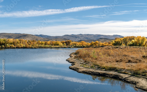 Fototapeta Naklejka Na Ścianę i Meble -  landscape with lake, autumn colored trees and blue sky