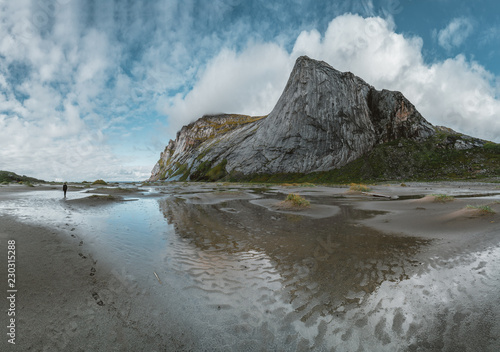 Hiking impressions at Bunes sand beach with view to Bunes Fjorden at Lofoten Islands in Norway on a blue sky with clouds sunny day. photo