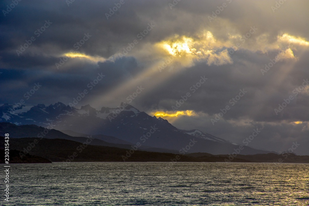 Sunlight piercing the clouds through the mountains of Patagonia, Argentine Sunlight piercing the clouds through the mountains of Patagonia, Argentine