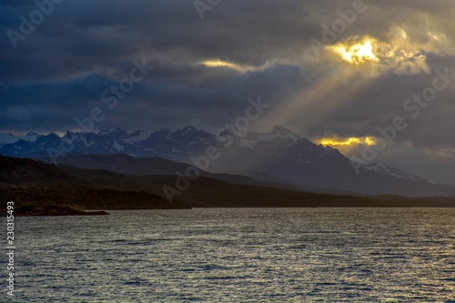 Canvas Print Sunlight piercing the clouds through the mountains of Patagonia, Argentine