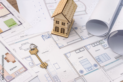 Wooden house model and key on house plan drawing