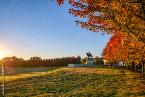 October 20, 2018 - St. Louis, Missouri - The sunrise and fall foliage around the Apotheosis of St. Louis statue of King Louis IX of France on Art Hill in Forest Park, St. Louis, Missouri. photo