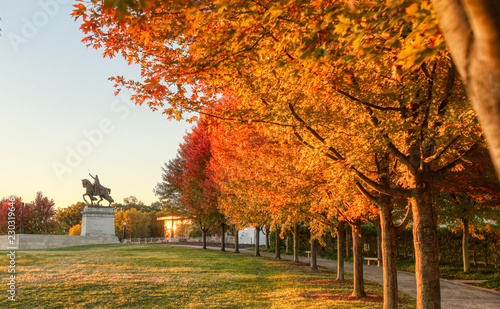 October 20, 2018 - St. Louis, Missouri - The sunrise and fall foliage around the Apotheosis of St. Louis statue of King Louis IX of France on Art Hill in Forest Park, St. Louis, Missouri. photo