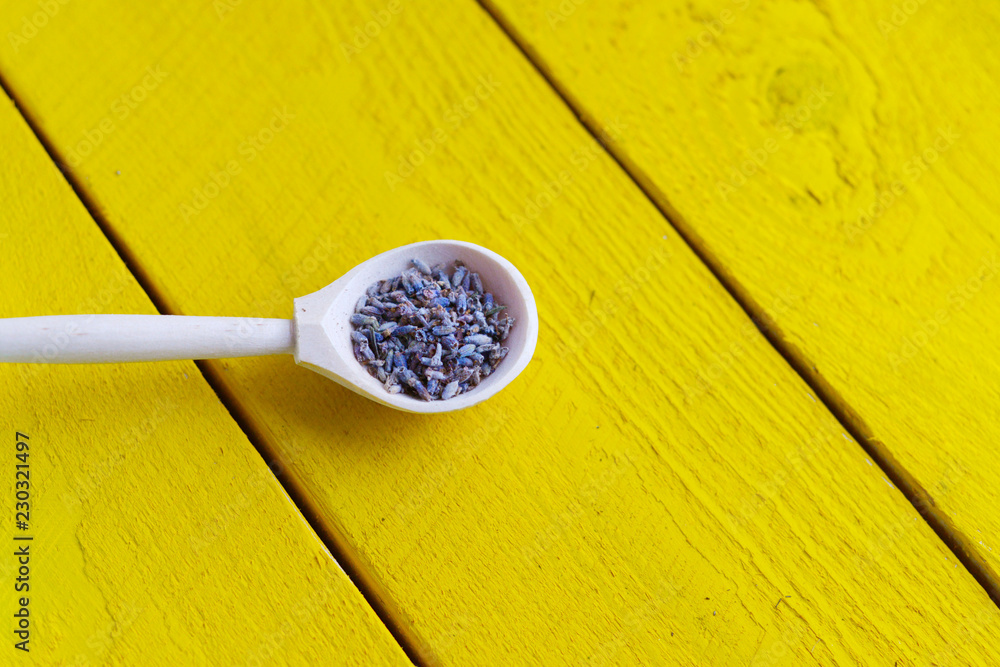 wooden spoon with dried lavender flowers on a yellow rustic wooden table wooden spoon with dried lavender flowers on a yellow rustic wooden table