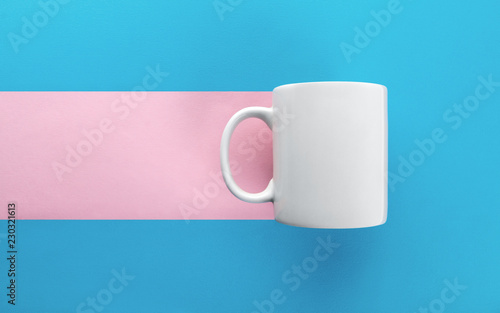 White mug on blue and pink background
