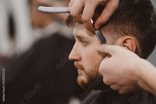 Barbershop Man in barber chair, hairdresser styling his hair razor