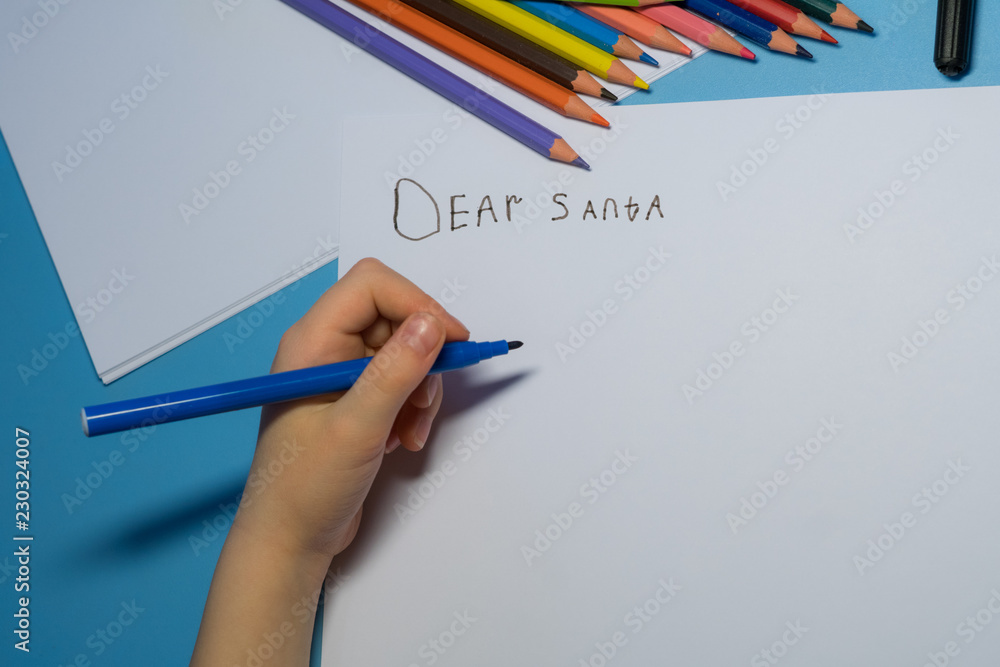 Little girl with pencils and felt-tip pens is writing a letter to Santa Little girl with pencils and felt-tip pens is writing a letter to Santa