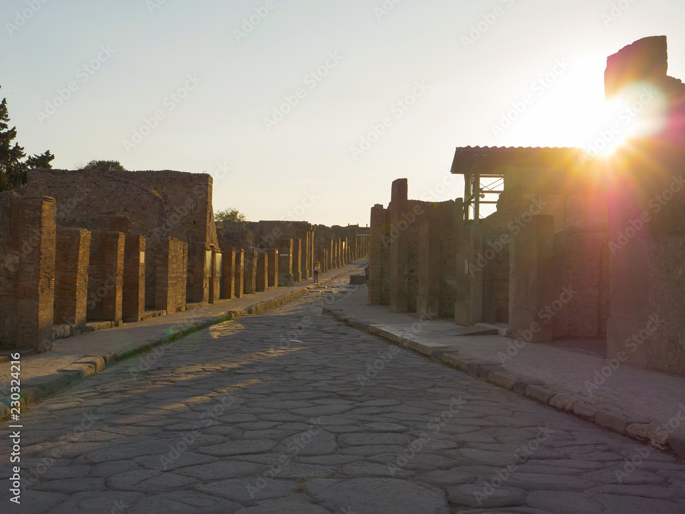 LENS FLARE Warm evening sun rays shine on the historic stone streets of Pompeii.