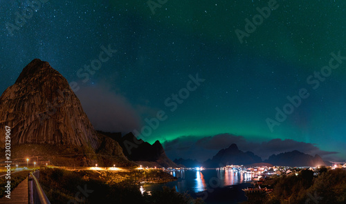 Northern Lights Aurora Borealis with classic view of the fisherman s village of Reine near Hamnoy in Norway, Lofoten islands. This shot is powered by a wonderful Northern Lights show.