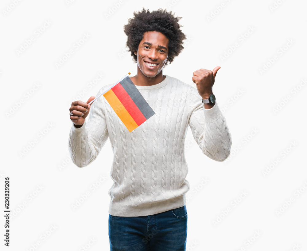 Afro american man flag of Germany over isolated background pointing and showing with thumb up to the side with happy face smiling Afro american man flag of Germany over isolated background pointing and showing with thumb up to the side with happy face smiling
