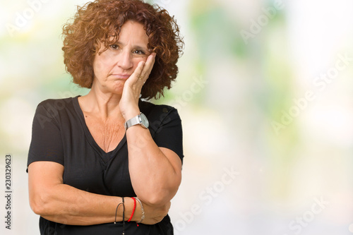 Beautiful middle ager senior woman over isolated background thinking looking tired and bored with depression problems with crossed arms.