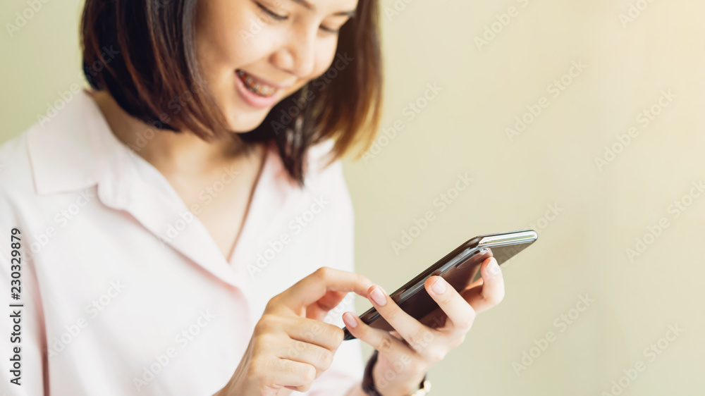 Woman using smartphone on room, During leisure time. The concept of using the phone is essential in everyday life. Woman using smartphone on room, During leisure time. The concept of using the phone is essential in everyday life.