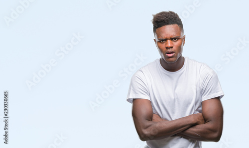 Young african american man over isolated background skeptic and nervous, disapproving expression on face with crossed arms. Negative person.