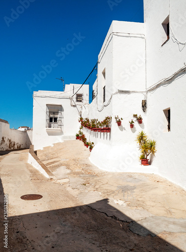 Close street with white houses decorated with pots