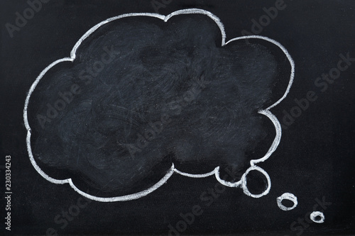 Chalk hand drawing blank thought bubble on blackboard 